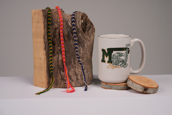 close up of bracelets on log and coffee mug on wooden coasters